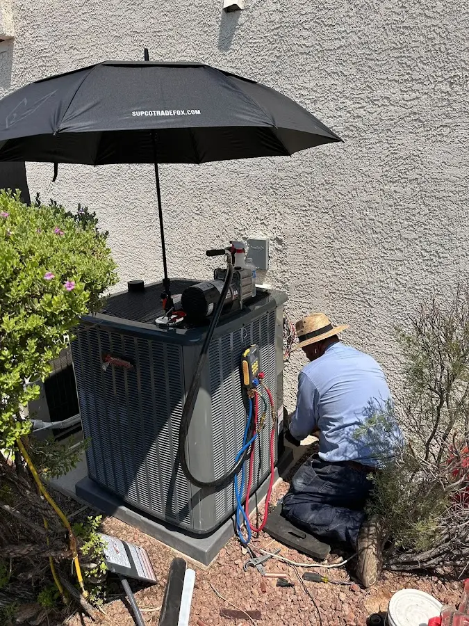 HVAC technician performing outdoor AC maintenance in Watertown